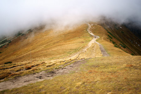 Man alone going ahead in the clouds in the mountains