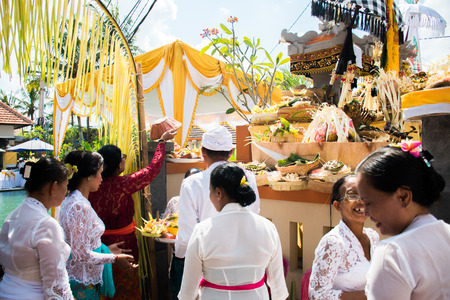 Procession of beautiful Balinese women in traditional costumes - sarong, carry offering on heads for Hindu ceremony. Arts festival, culture of Bali island and Indonesia people, Asian travel backgroundのeditorial素材