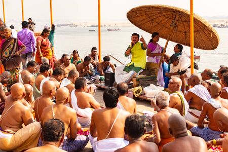 VARANASI, INDIA, MAR 10 2019 - Hindu monks conduct a ceremony to meet the dawn on the banks of the Ganges, and raise the Indian flag.のeditorial素材