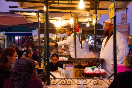 MARRAKESH, MOROCCO, NOVEMBER 10 2018: Unidentified people selling food at night at the Djemaa el Fna square in Marrakesh, Africaのeditorial素材