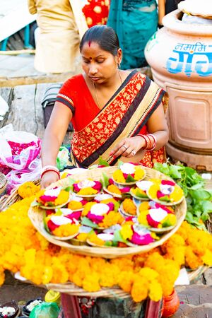 Varanasi. India, Mar 10 2019 - A Indian woman selling floral candles to float as offerings on the Holy River Ganges at Varanasi in the Uttar Pradesh region of Indiaのeditorial素材