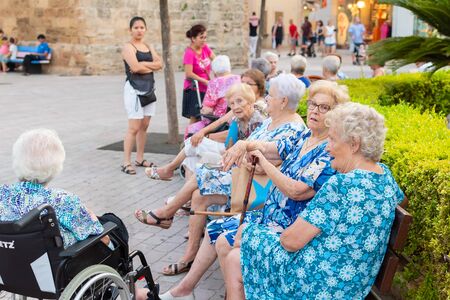 Palma de Mallorca Spain, 8 July 2019 - Senior tourists enjoying sightseeing in old narrow of Alcudia Town, Mallorcaのeditorial素材