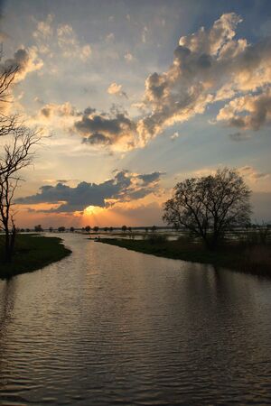 Sunset over spring flooded meadowsの写真素材