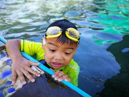 Children swimming. Boy Practice Swimming. Activities on the pool, playing in water, happiness and holiday.の写真素材