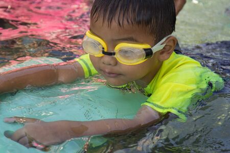 Children swimming. Boy Practice Swimming. Activities on the pool, playing in water, happiness and holiday.の写真素材