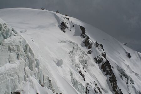 Snowy mountain range and a dark skyの写真素材