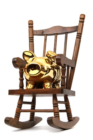old wooden rocking chair and golden piggy bank on whiteの写真素材