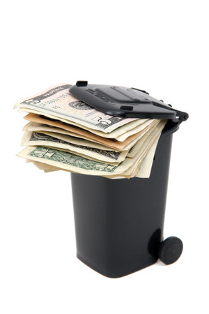 batch of bank notes in black rubbish bin on whiteの写真素材