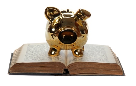 old book with golden piggy bank on whiteの写真素材