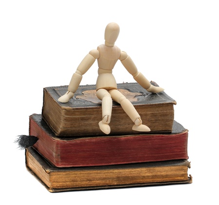 wooden doll sit on old booksの写真素材