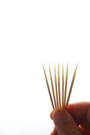 Hand showing some wooden chopsticksの写真素材