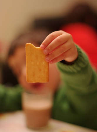 Dunking a cookie in milk for breakfastの写真素材
