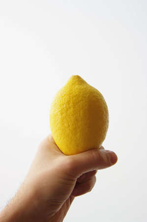 A hand showing a yellow lemonの写真素材