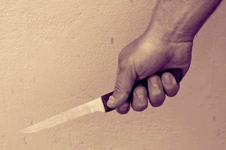 mans hand with a knife toned