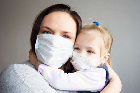 a mother with a child in medical masksの写真素材