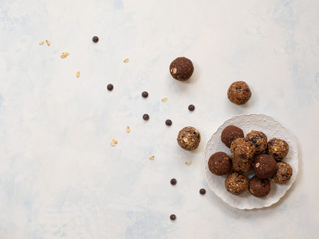 Healthy energy balls with oatmeal, agave syrup, cocoa and chia seeds on a white background. Copy...