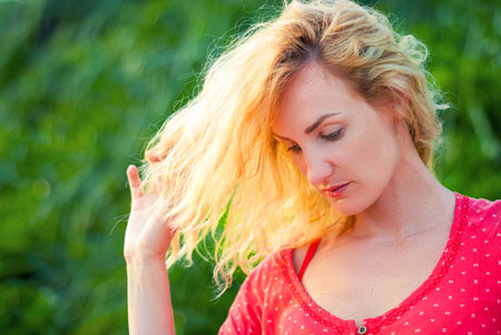 Beautiful middle-aged woman blond is sad. The face of a beautiful girl with flying hair.