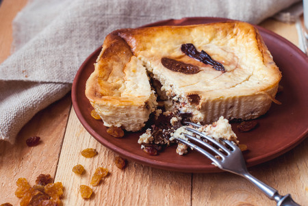 Cottage cheese casserole with figs and raisins with a glass of milk on a wooden background. A cracked cheesecake with figs and milk. Cupcake with figs nuts and raisins on a wooden background.の写真素材