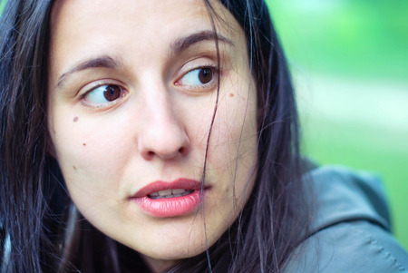 The face of a beautiful girl without makeup with black eyes and hair with freckles.の写真素材