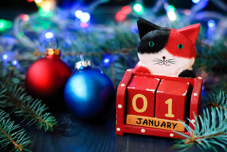 Wooden New Year calendar with date in garlands, Christmas tree branches and New Year's toys January...