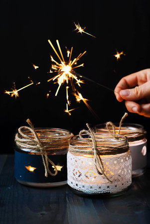 Candles and Bengal lights in hand on a black backgroundの写真素材