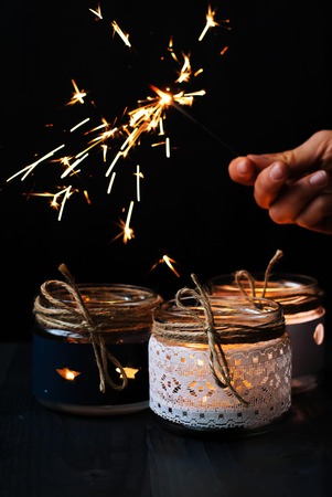 Candles and Bengal lights in hand on a black backgroundの写真素材