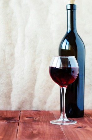 Glass of red wine on a wooden tableの写真素材