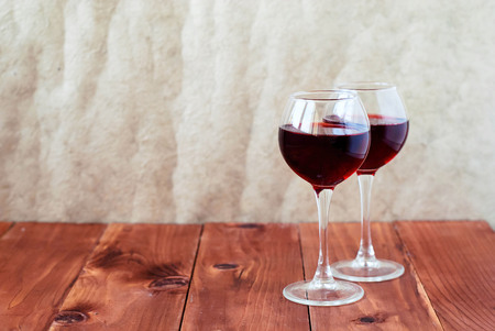 Two glasses of wine on a wooden tableの写真素材