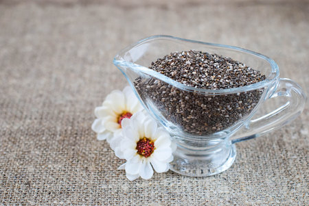 Chia seeds in a glass jug on a linen tableclothの写真素材