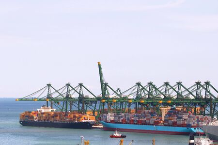 Loading of cargo on/off container ships, image can be used to show a busy port, prosperity of a harbour.の写真素材