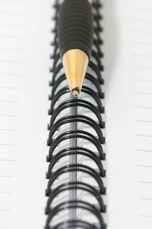 Empty blank ring, spiral notepad, gold pen closeupの写真素材