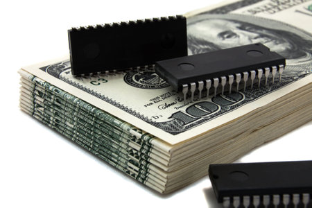 Computer chips on money, signify the cost of chips, and electronicsの写真素材