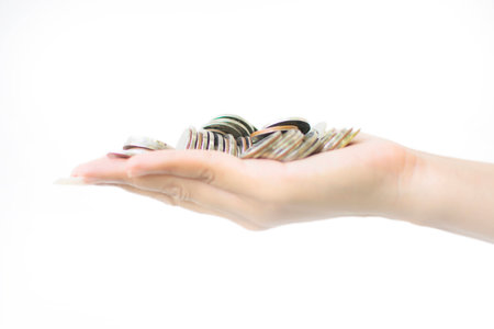 Handful of coins in palm  hand of woman in white backgroundの写真素材