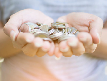 Female holding a pile of coins by two handの写真素材