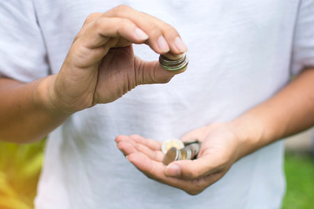 Soft focus of Asian man hand  counting Thai coins in his hand