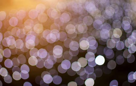 Abstract defocused of purple light on orange light shine backgroundの写真素材