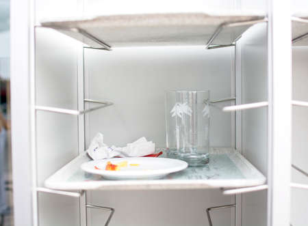 Empty dirty white plate with tissue paper and glass on the metal shelves with trayの写真素材