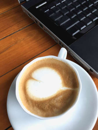 coffee, cup, hot, table, latte, drink, laptop, beverage, caffeine, cappuccino, mug, vintage, background, white, brown, wood, breakfast, cafe, milk, break, foam, espresso, mocha, wooden, art, fresh, life, top, cream, aroma, love, heartの写真素材