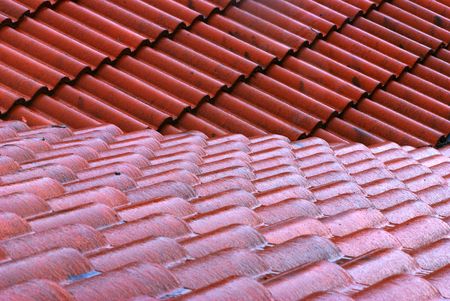 A downward looking of two overlapping roof with red tiles running different orientation on a rainy day.の写真素材