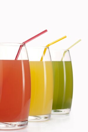three glasses of red, green and yellow juiceの写真素材