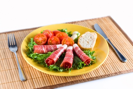 Bacon snack with vegetables on a plateの写真素材