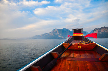 Wooden boat in the lake with beautiful sky and mountains