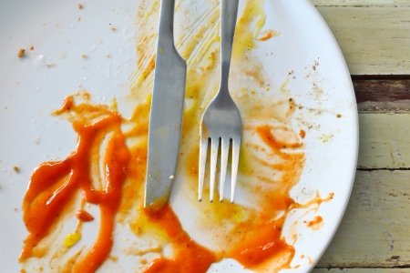 Empty dish after eat' knife and fork on dish backgroundの写真素材