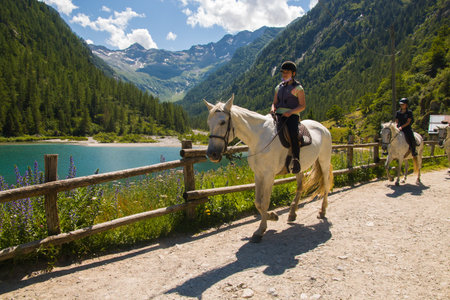 LAGO DELLE FATE, ITALY - JULY 20, 2021: View of fairy lake (Lago delle fate) with beautiful horses in Valle Anzasca, Piedmont alps, Italyのeditorial素材