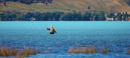 Fisherman in New Zealand lakeの写真素材