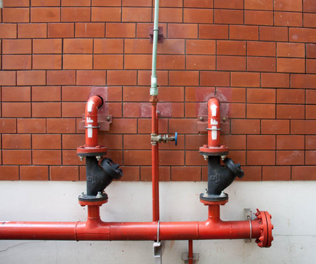 A pipe on the outside of a brick building in an old reconverted factory.