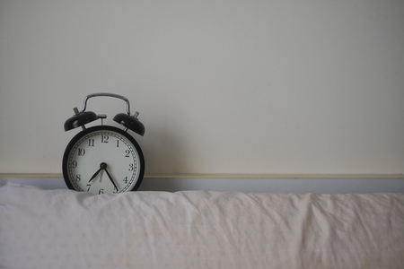 Classic alarm clock on the bedの写真素材