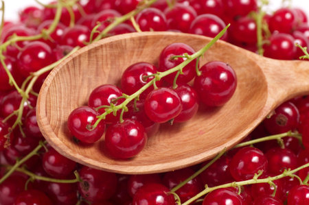 Red currant in wooden spoon