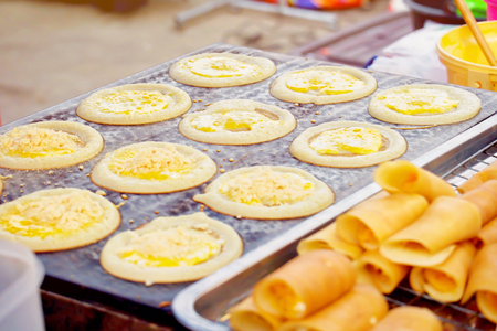 Soft waffle with cream or Roll pancake stuffed with cream on the stove.Thai dessert in market.の写真素材