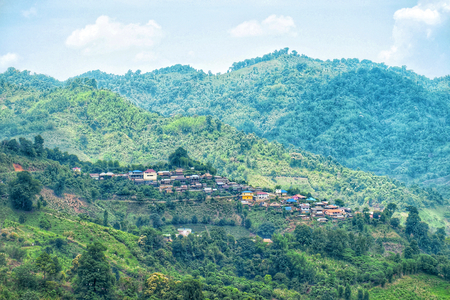 Village in the valley. Living in the forest. Small house in the mountain with sunlight. Small home in the hill with blue sky and cloud at Doi mae salong, Chiang Rai, Thailand.の写真素材